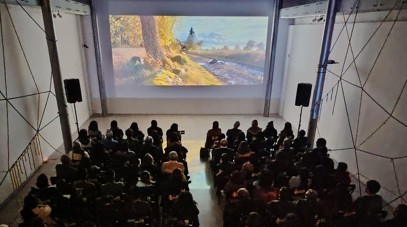 A big audience at a film screening in a museum.