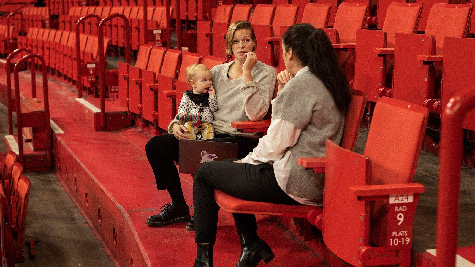 Two women having a work meeting  one of them holding a baby.