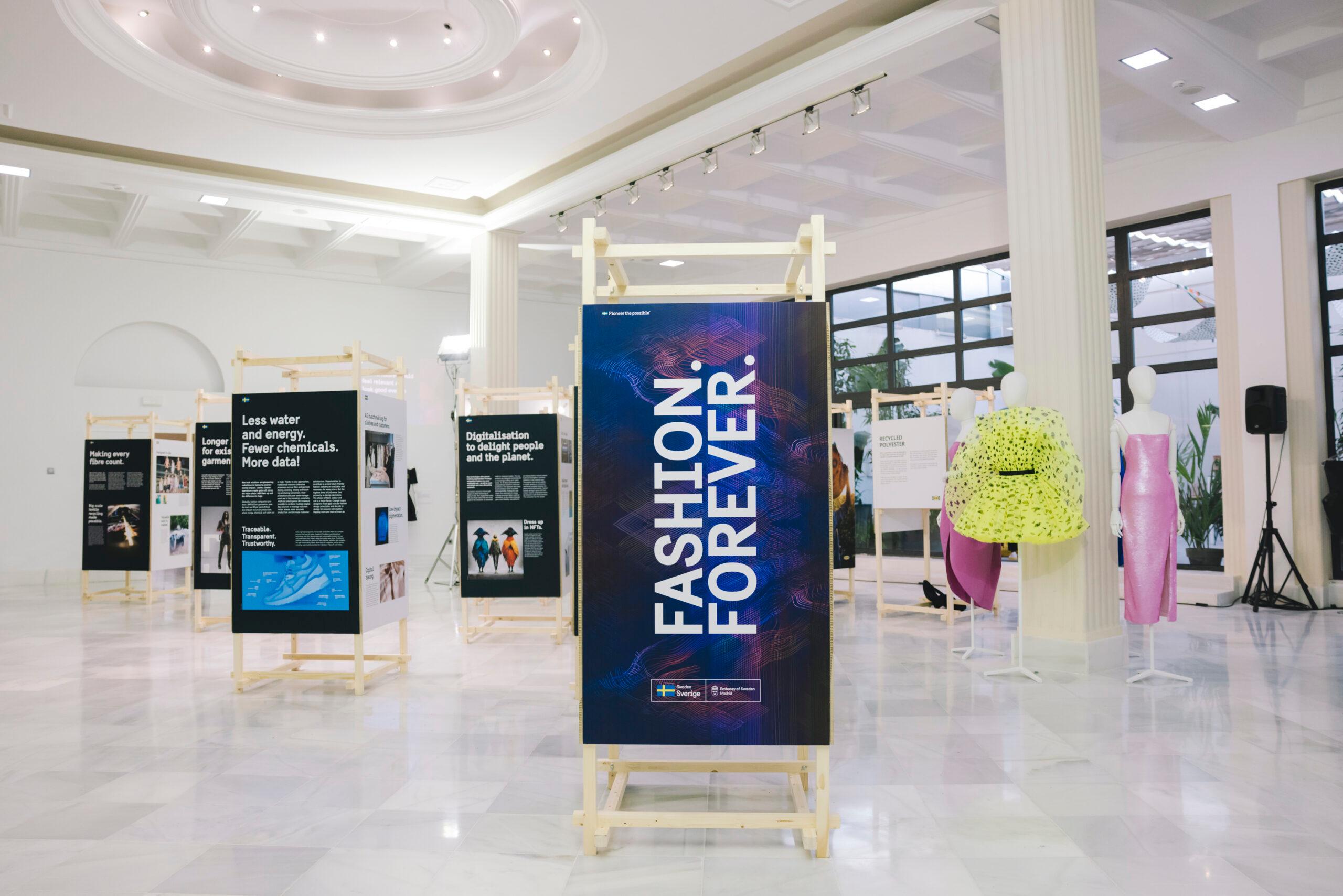 The exhibition and dresses showcased in a white room with marble floors.