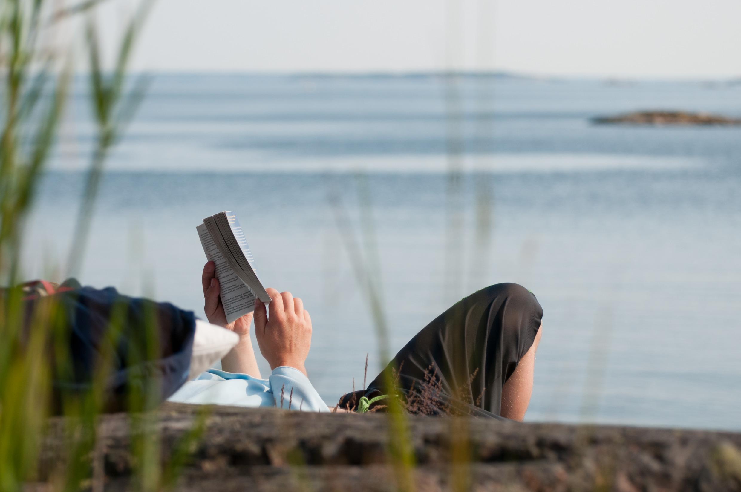 A person reading by the waterfront