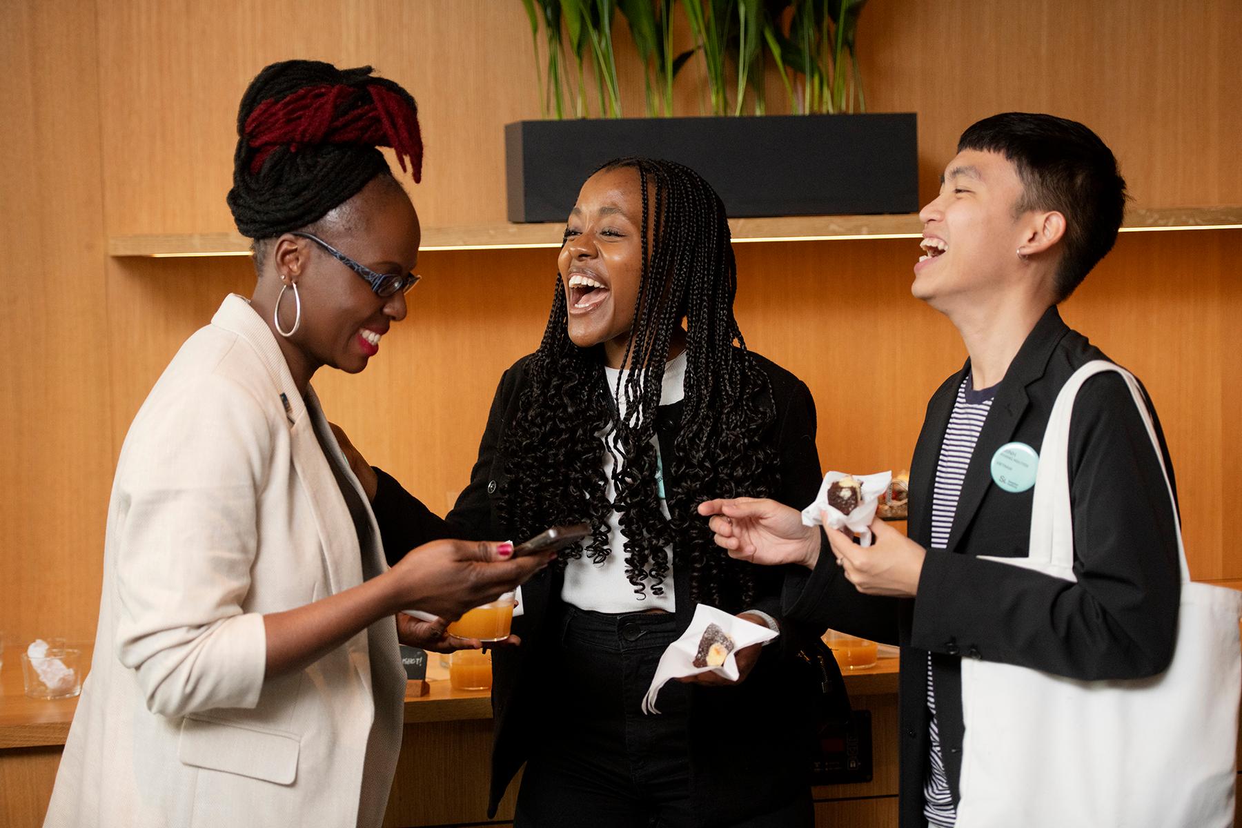 Three alumni from different countries laughing while talking.