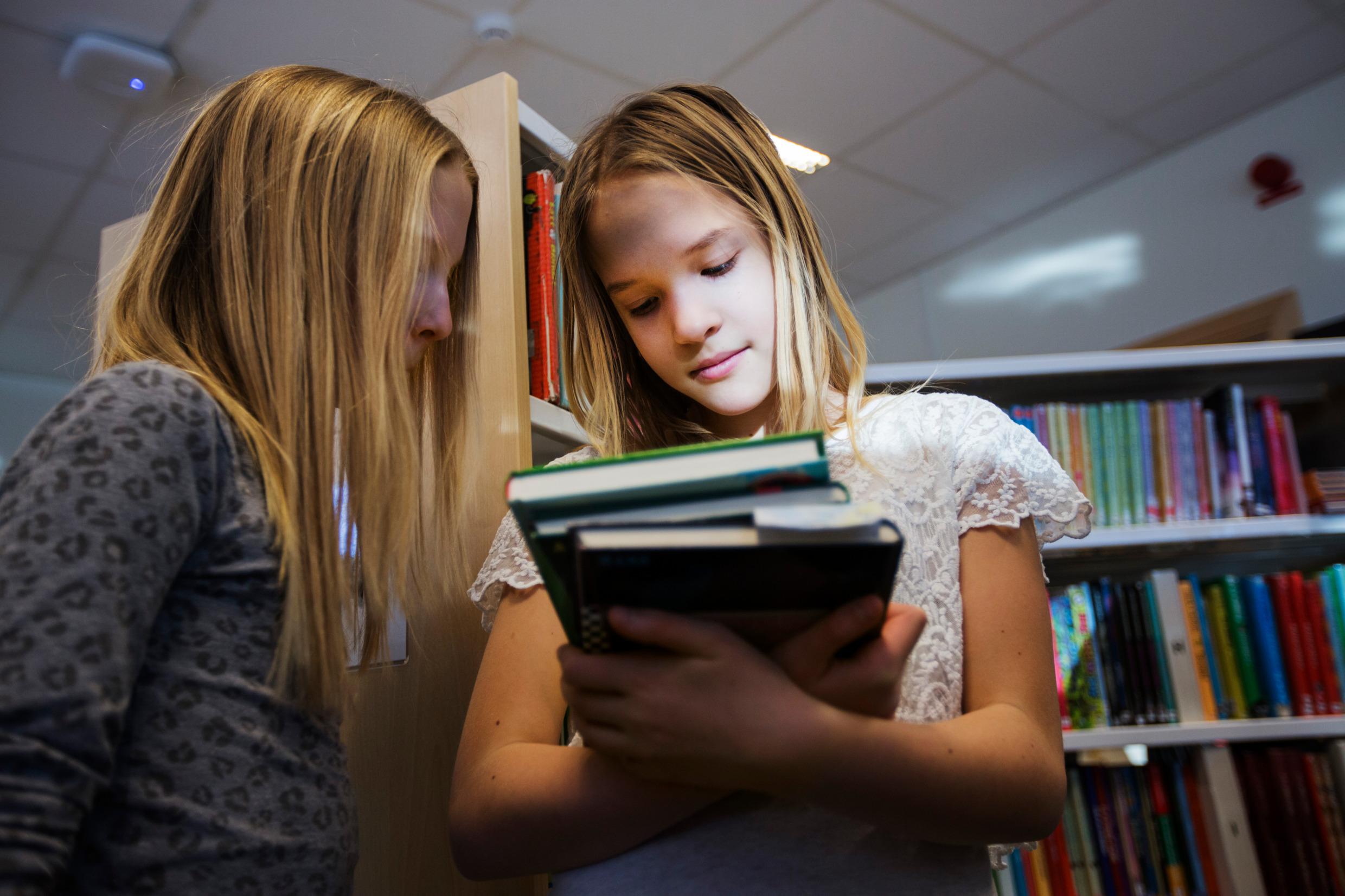 Two children checking out library books