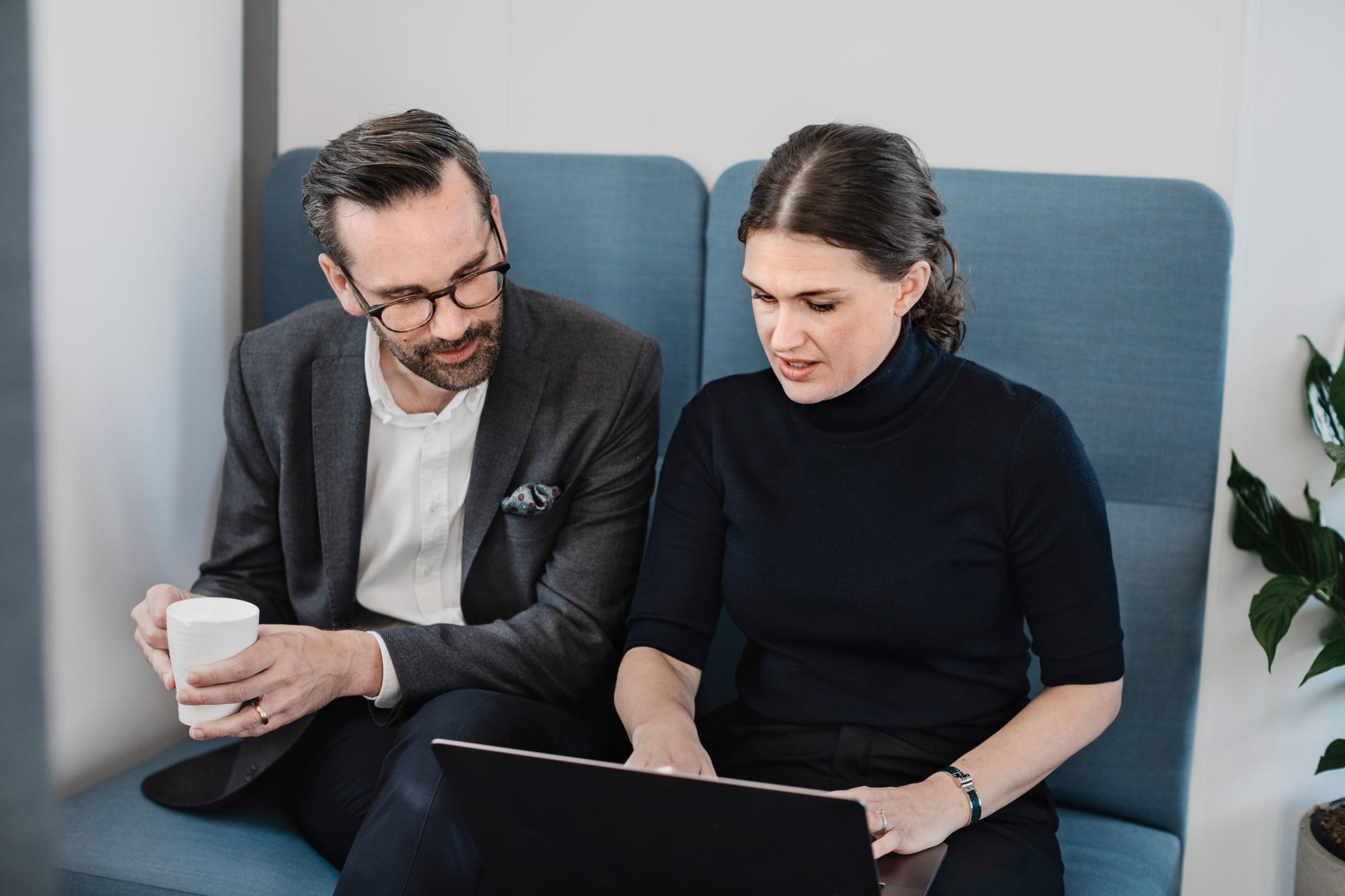 Two coworkers with a laptop, working together.