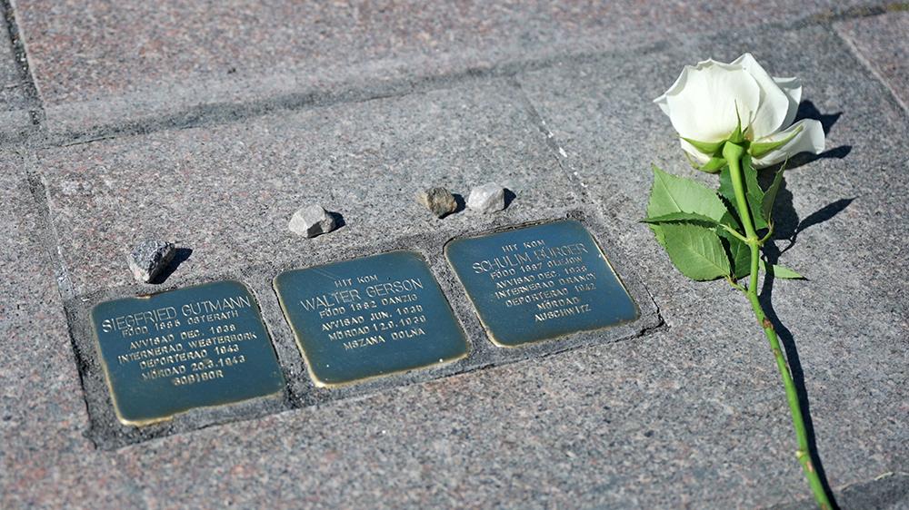 Tre small stone plaques and a white rose.