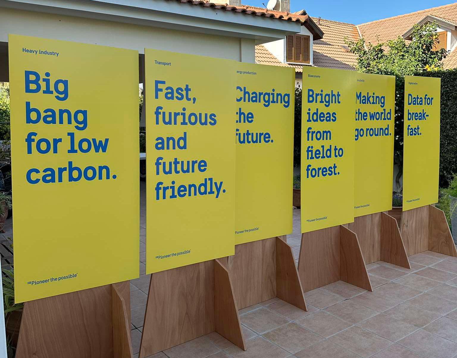 Wood modules outdoors with yellow posters. 