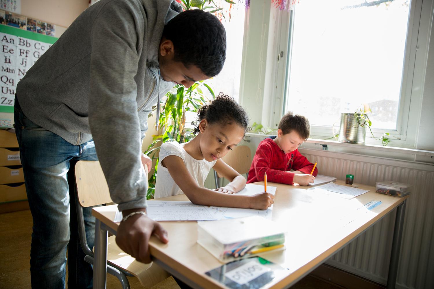 A child getting help from a teacher.