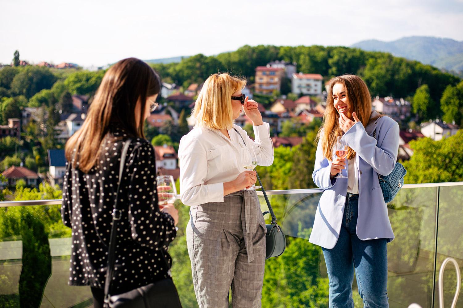 Three women talking outdoors in the sun in Zagreb.