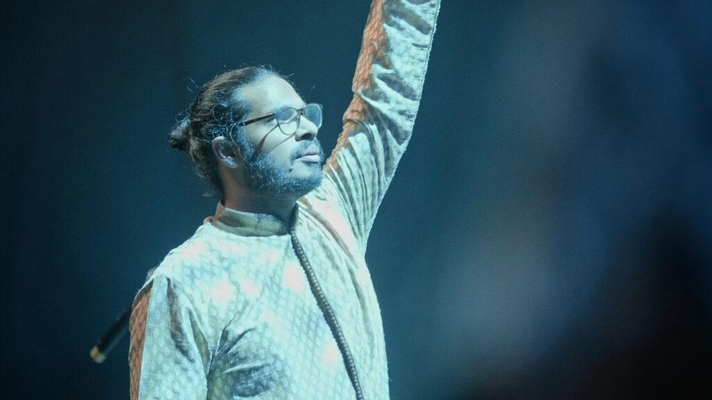 A choir leader standing in a spotlight.