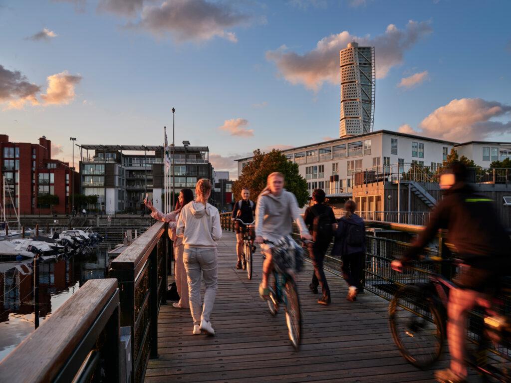 Pedestrians and bicyclists crossing a city bridge.