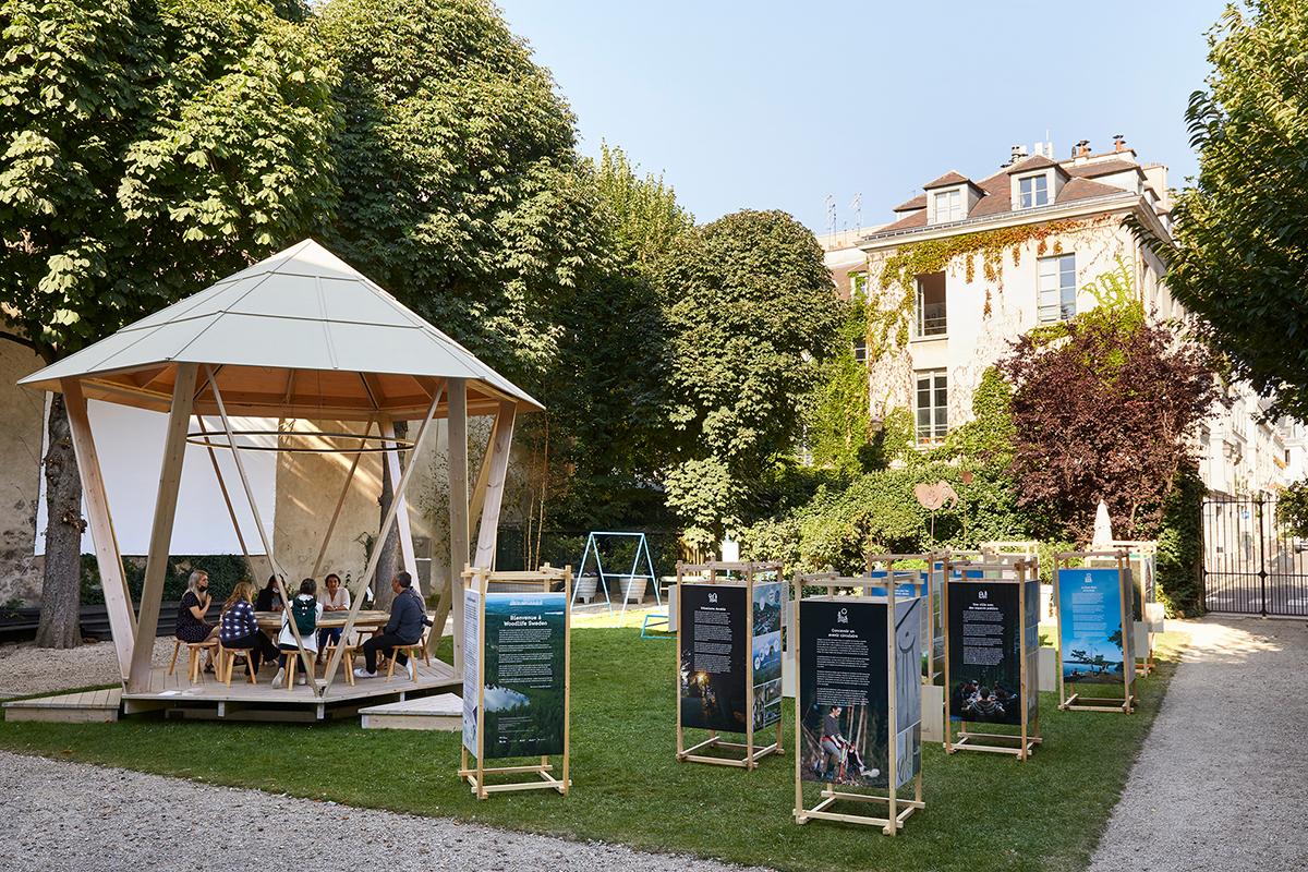 The exhibition and a wood pavilion in an old beautiful garden.