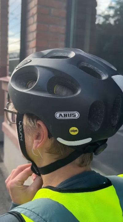 A person wearing a helmet with the yellow MIPS mark.