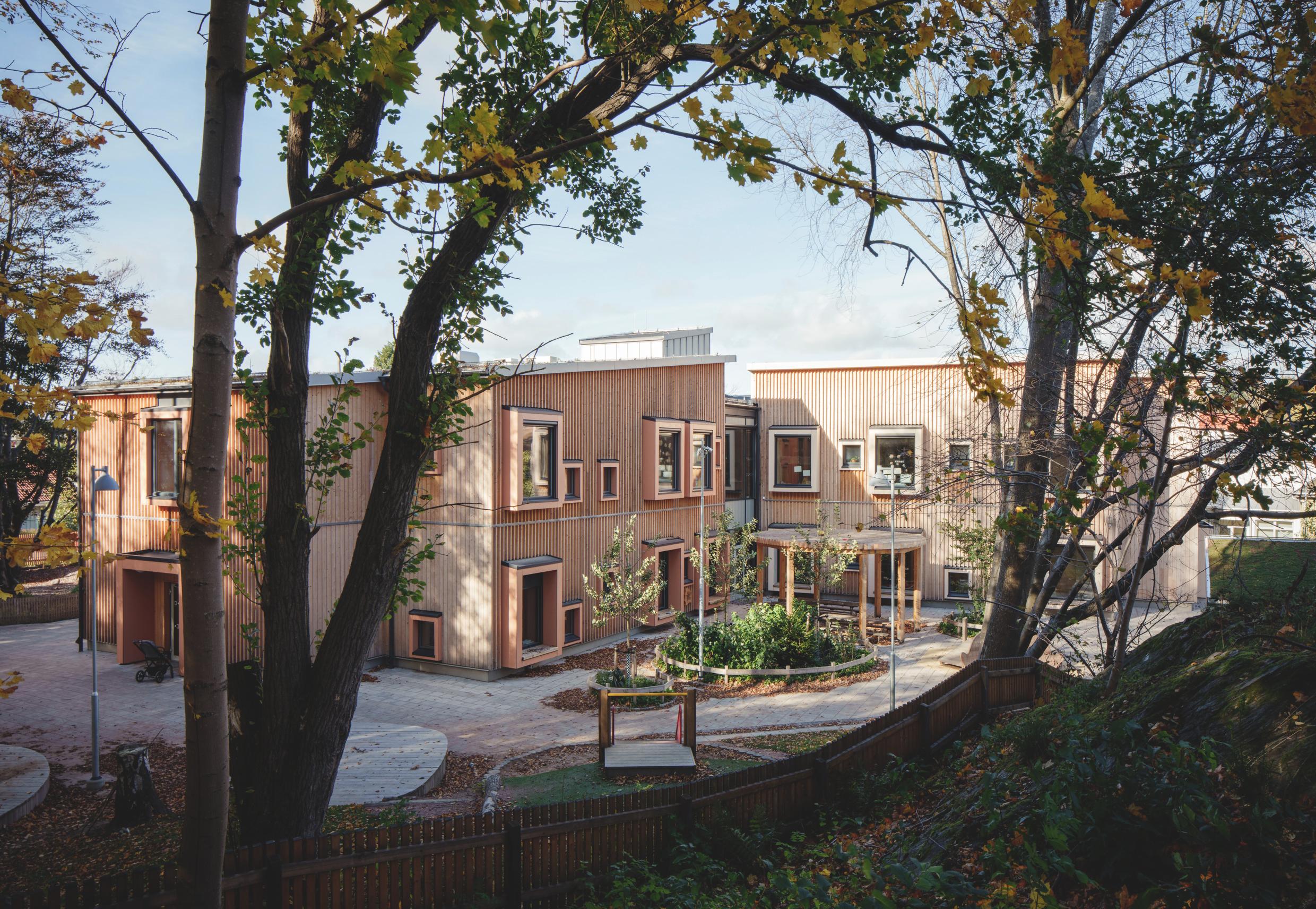 Wooden buildings seen through trees.