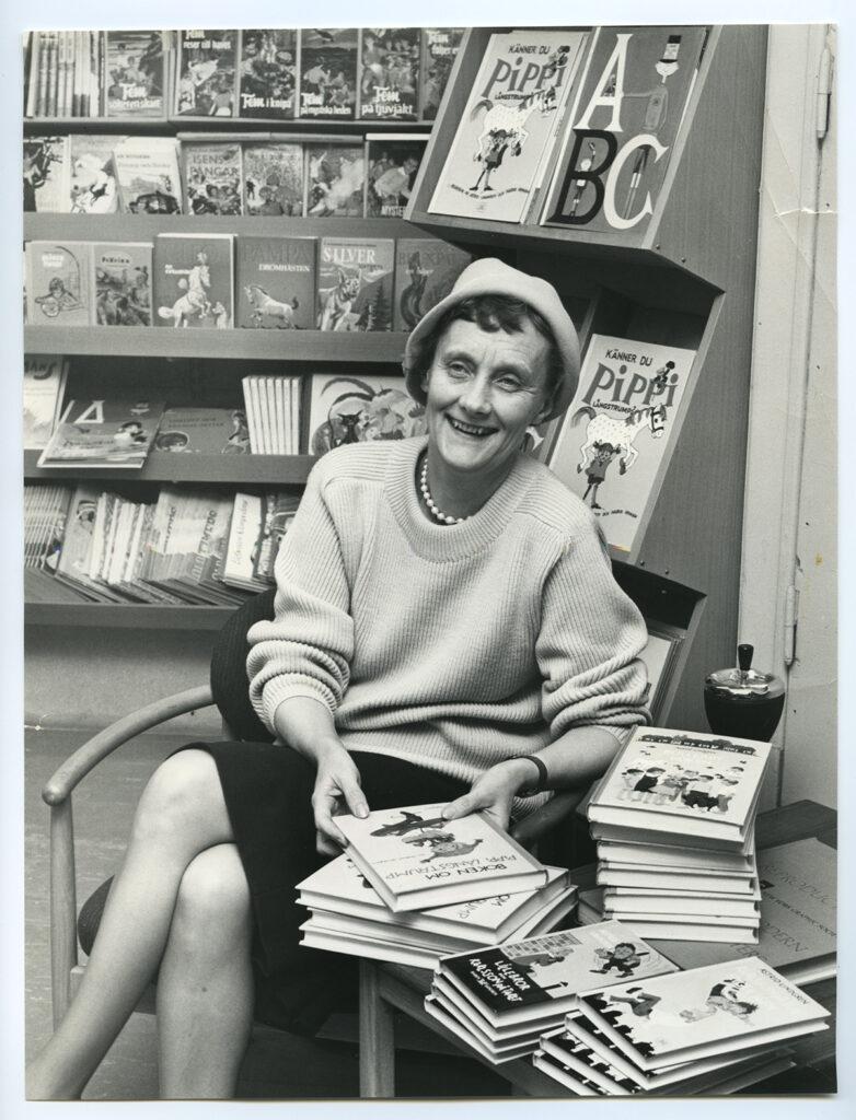 Astrid Lindgren in a library with many of her books.