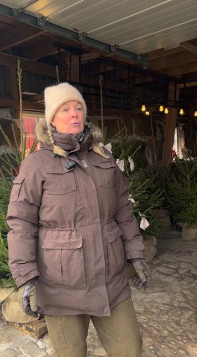 A woman selling Christmas trees.