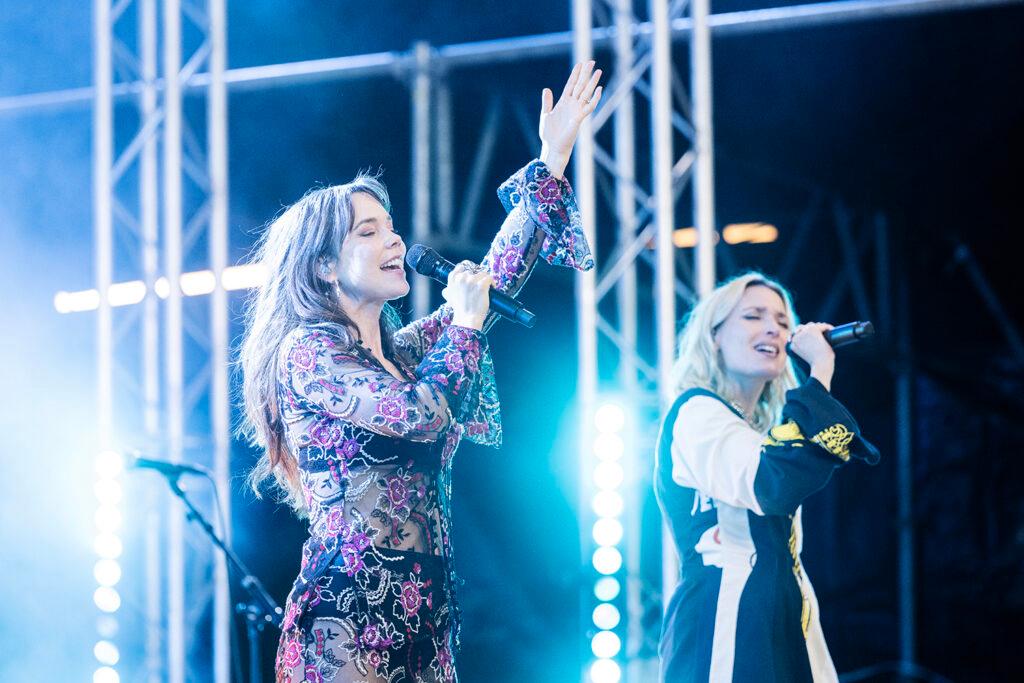 Two female singers on a stage together.