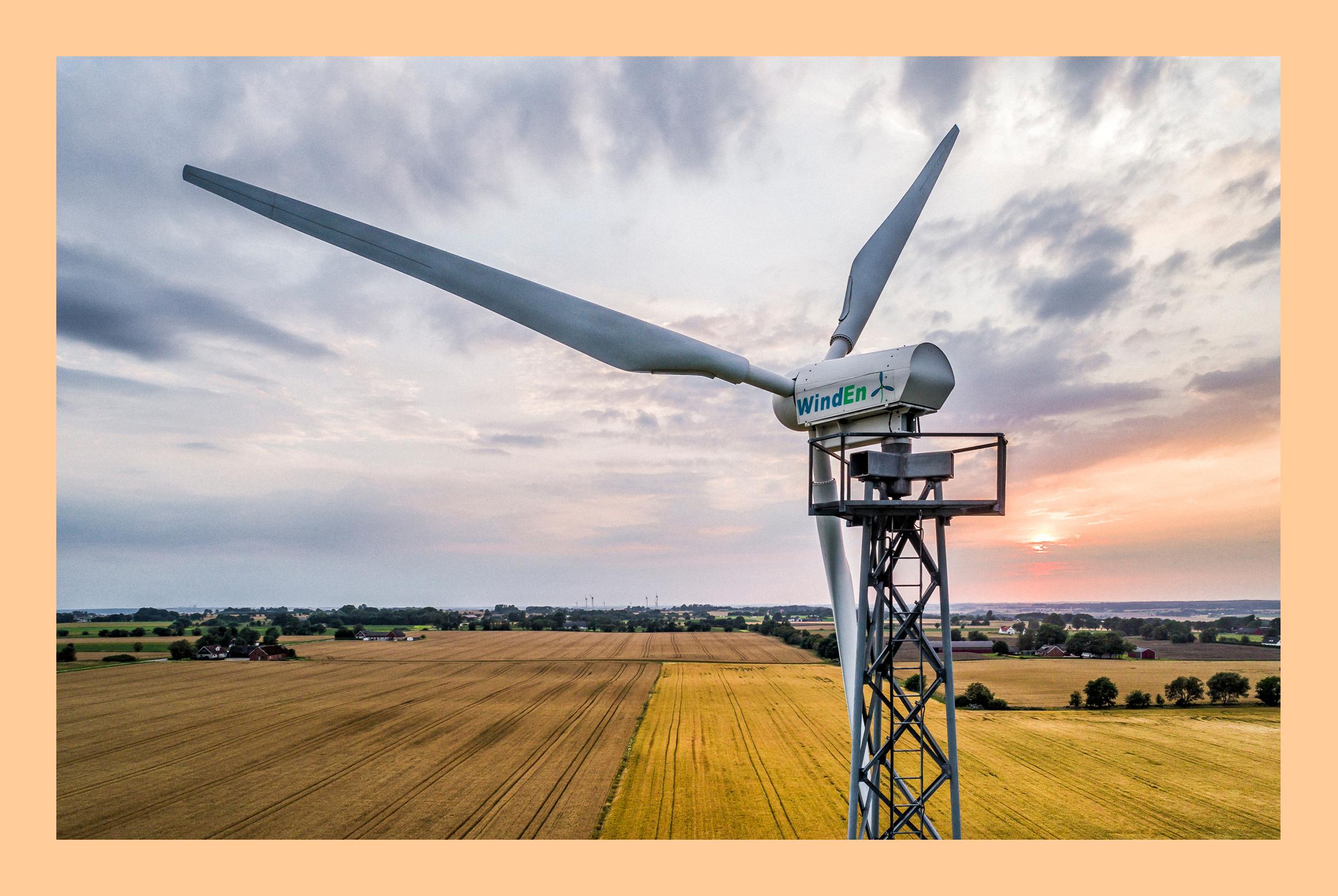 A wind power plant at a yellow field in Sweden.