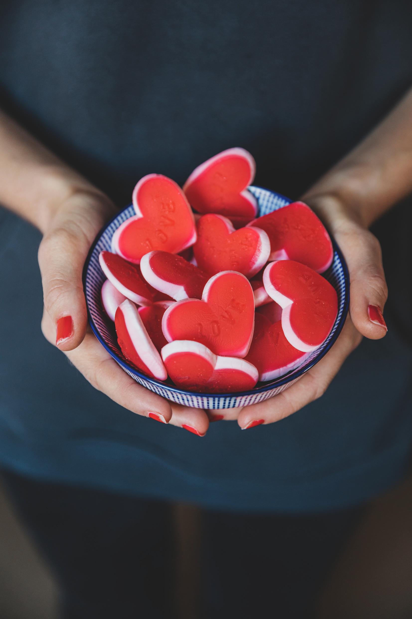 Red heart-shaped jelly candy pieces in a bowl.