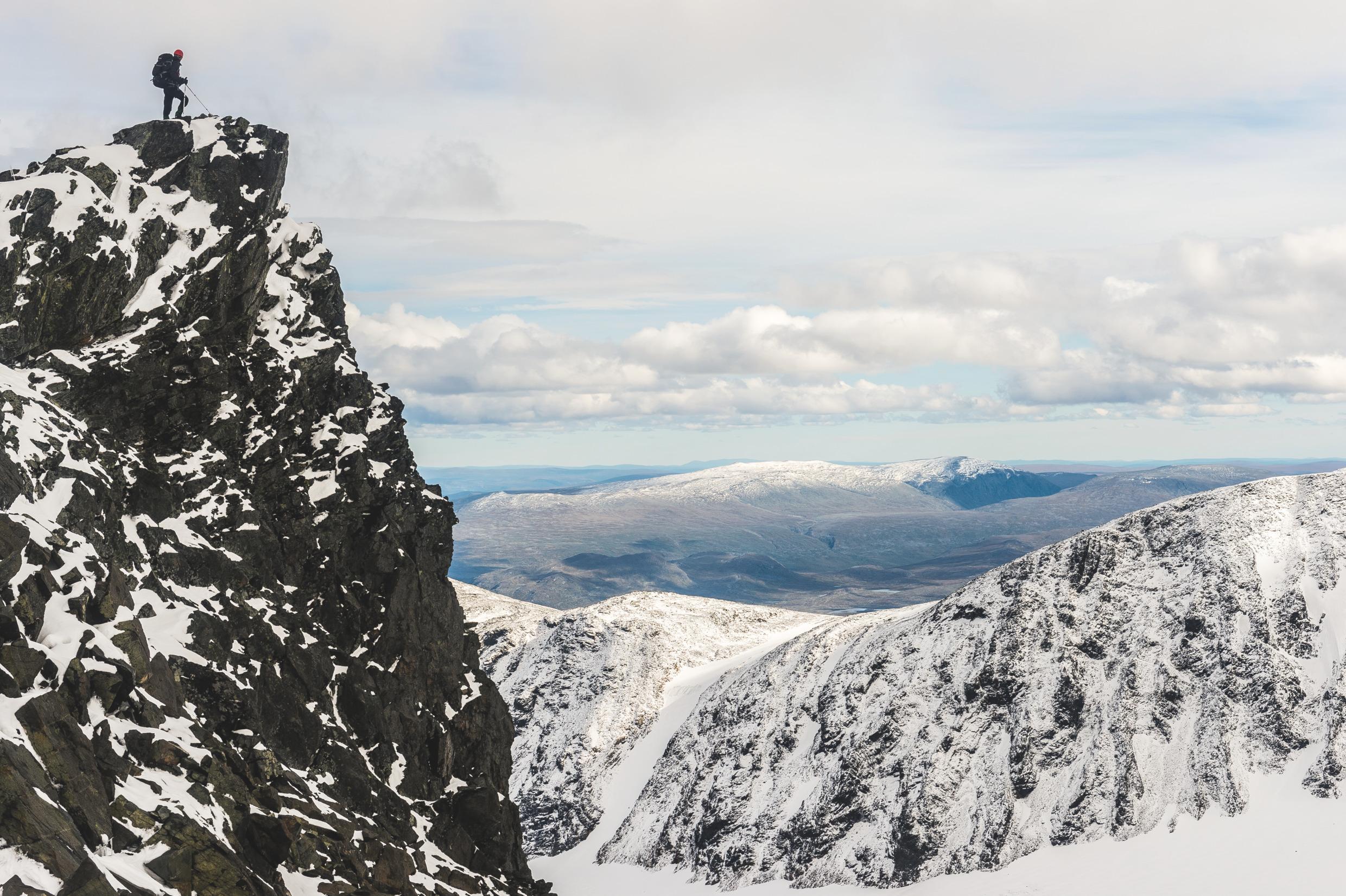 A person on the top of a snow-covered mountain.