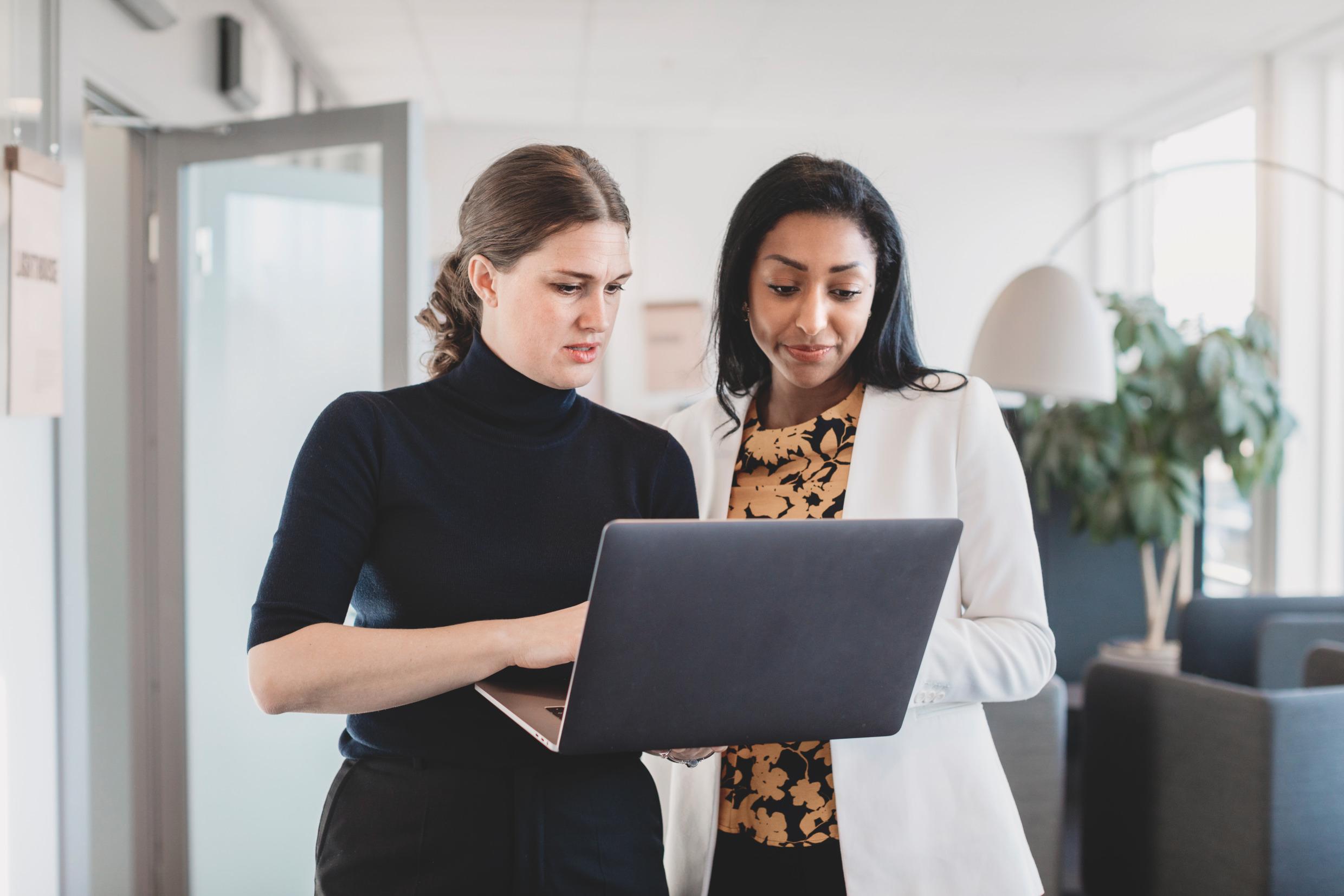 Two women looking at a laptop-