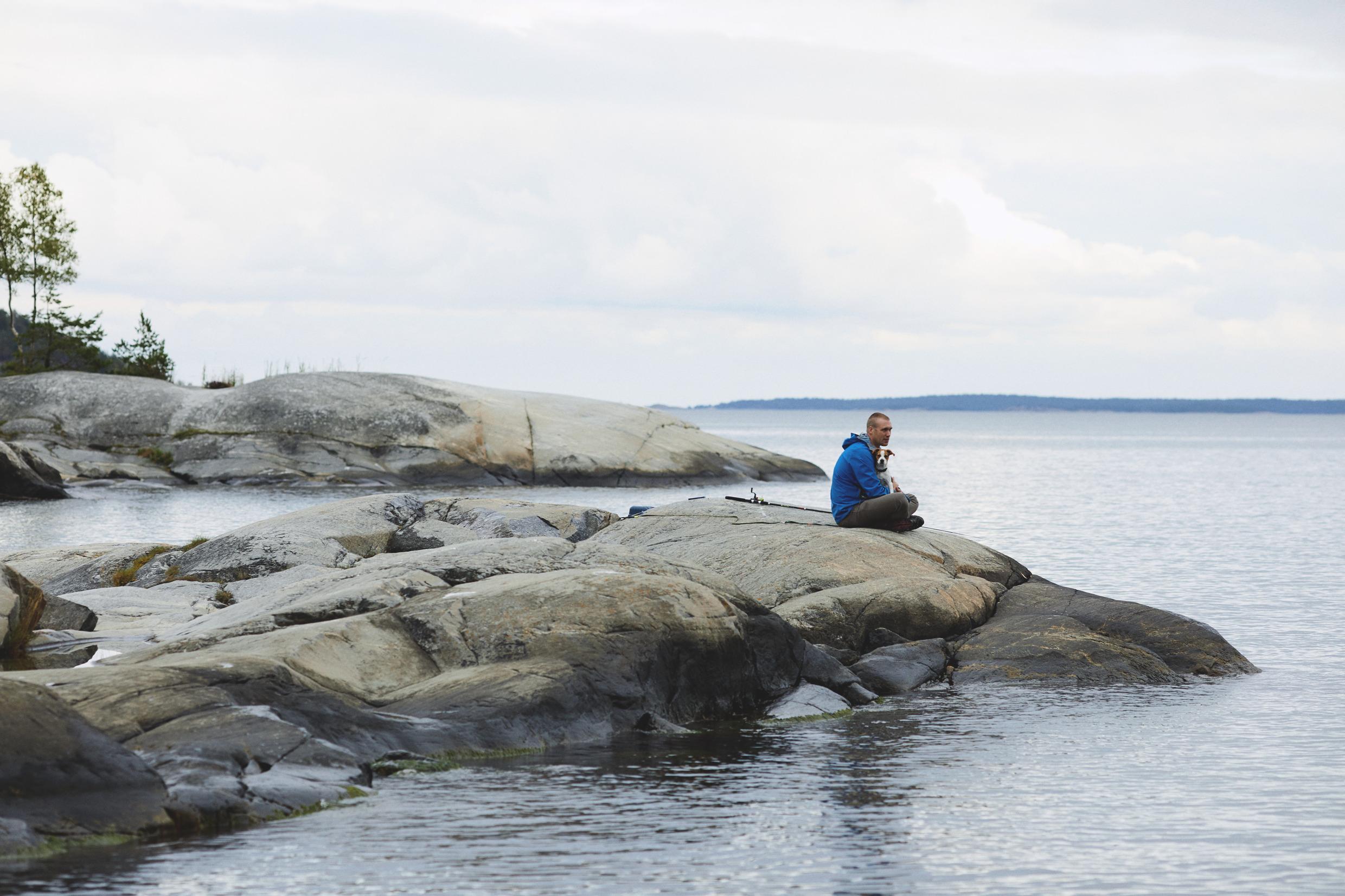A person on a stone beach by the water.