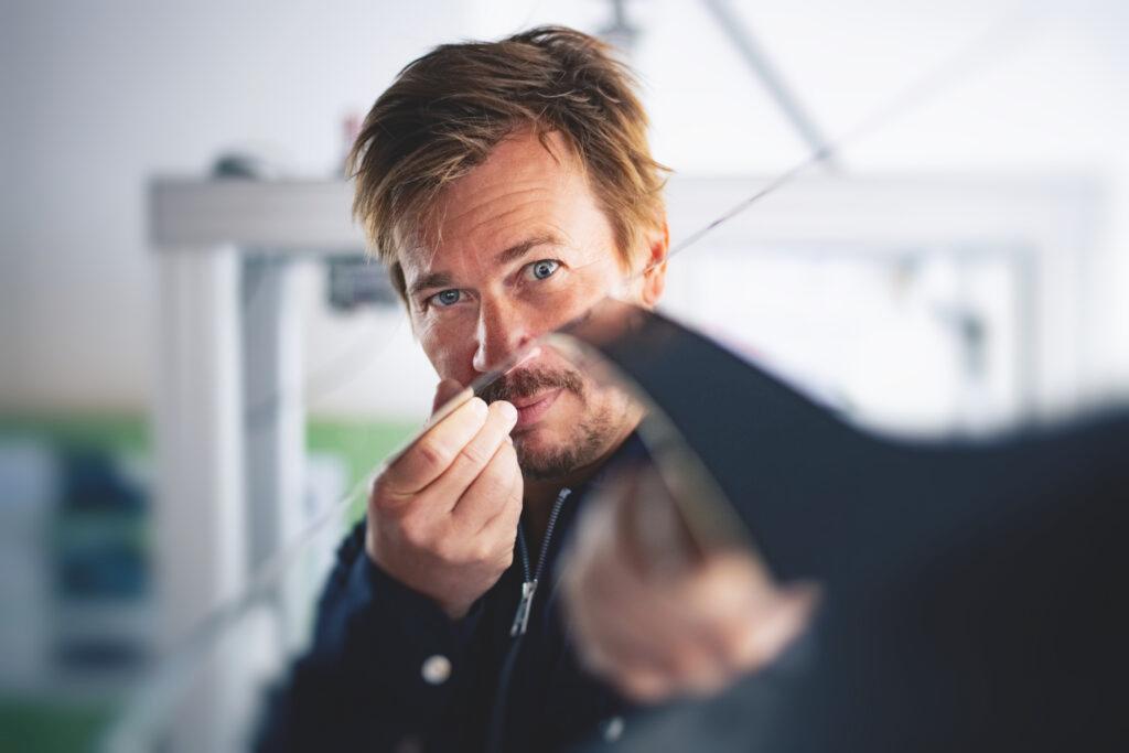 A man examines a piece of metal.