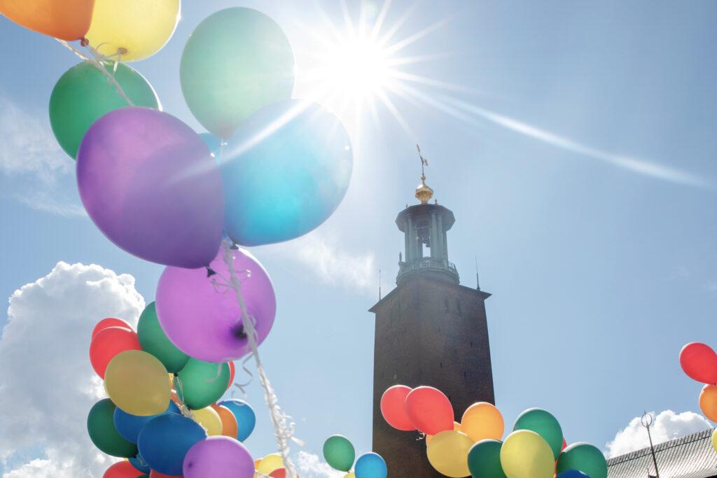 Rainbow balloons in front of the tower of Stockholm city hall.