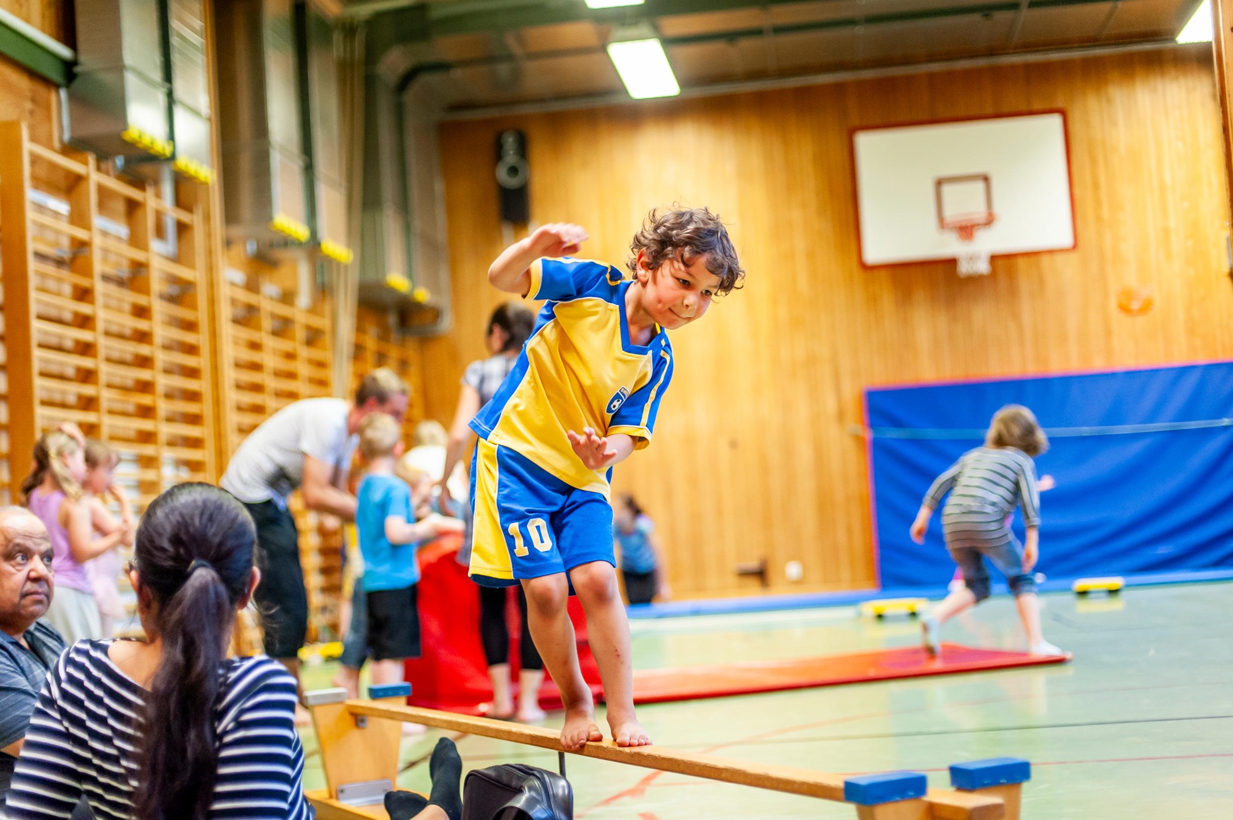 Children in a gymnastics hall doing all kinds of activities.