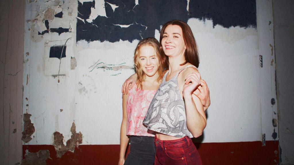Two smiling models wearing garments from Streamateria.