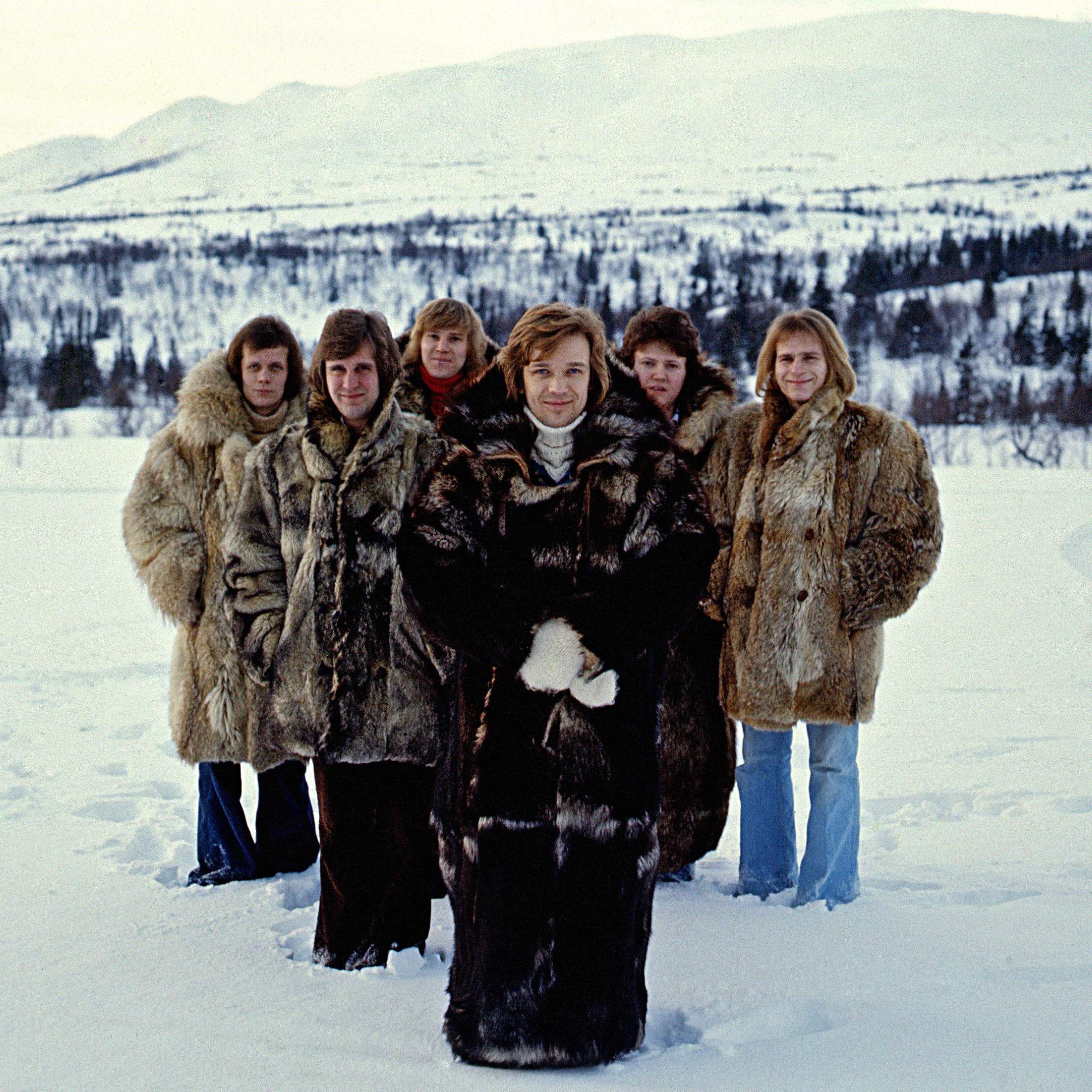The band Blue Sweden portrayed outdoors, in a wintry landscape, all wearing fur coats.