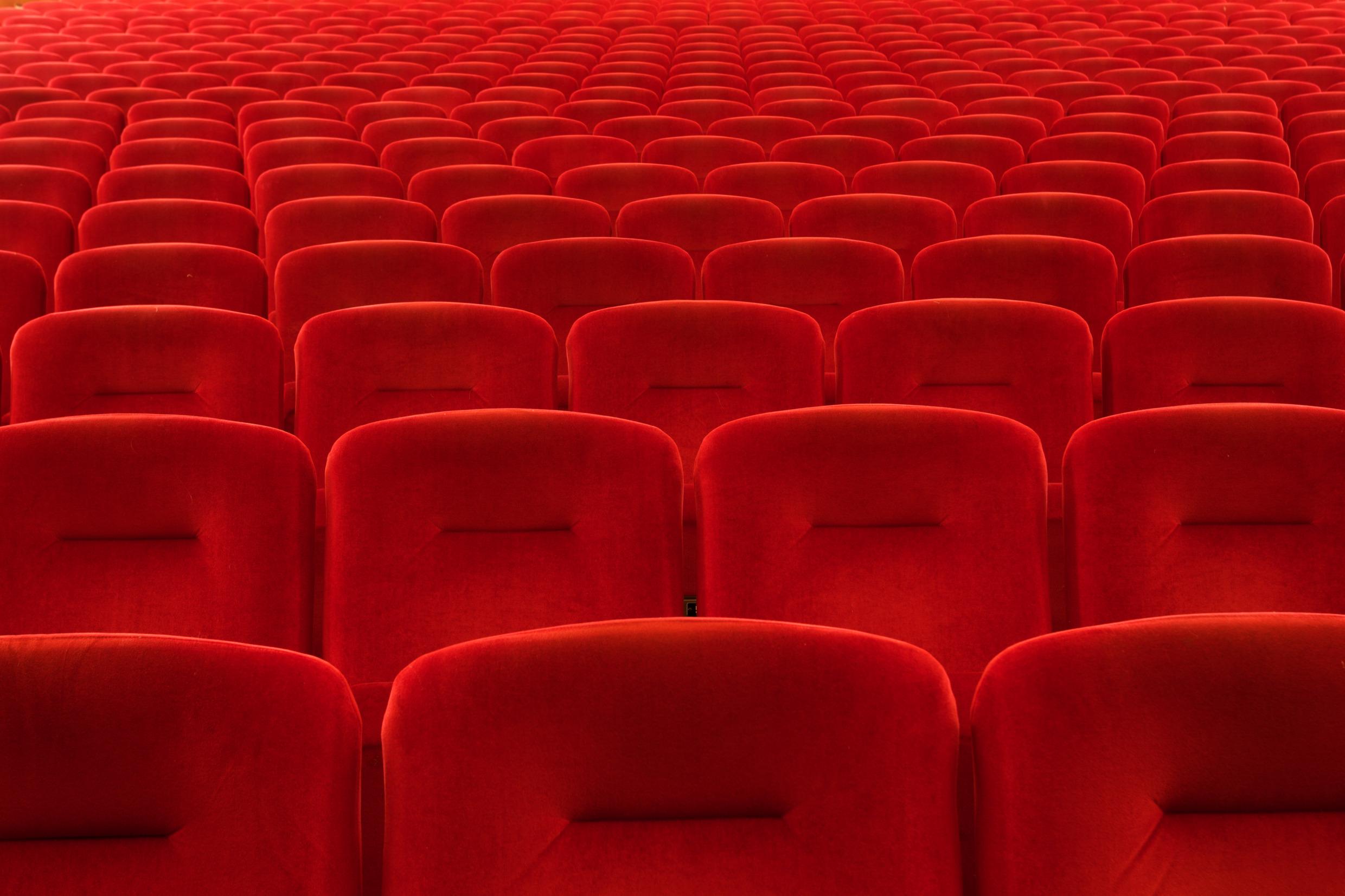 Classic red seats in an older movie theatre.