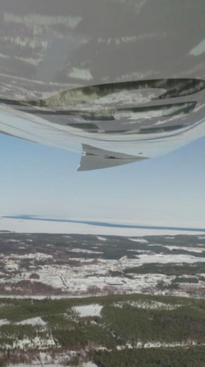 A northern landscape mirrored on the wing of a plane.