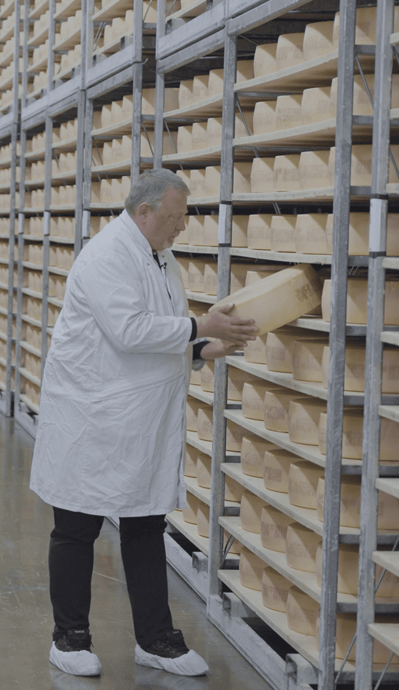 The cheese master placing cheese in storage
