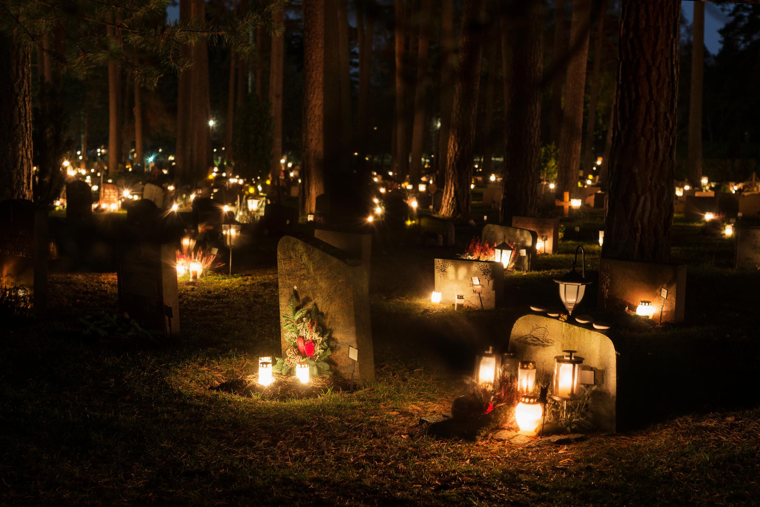 A cemetery with gravestones and candles.