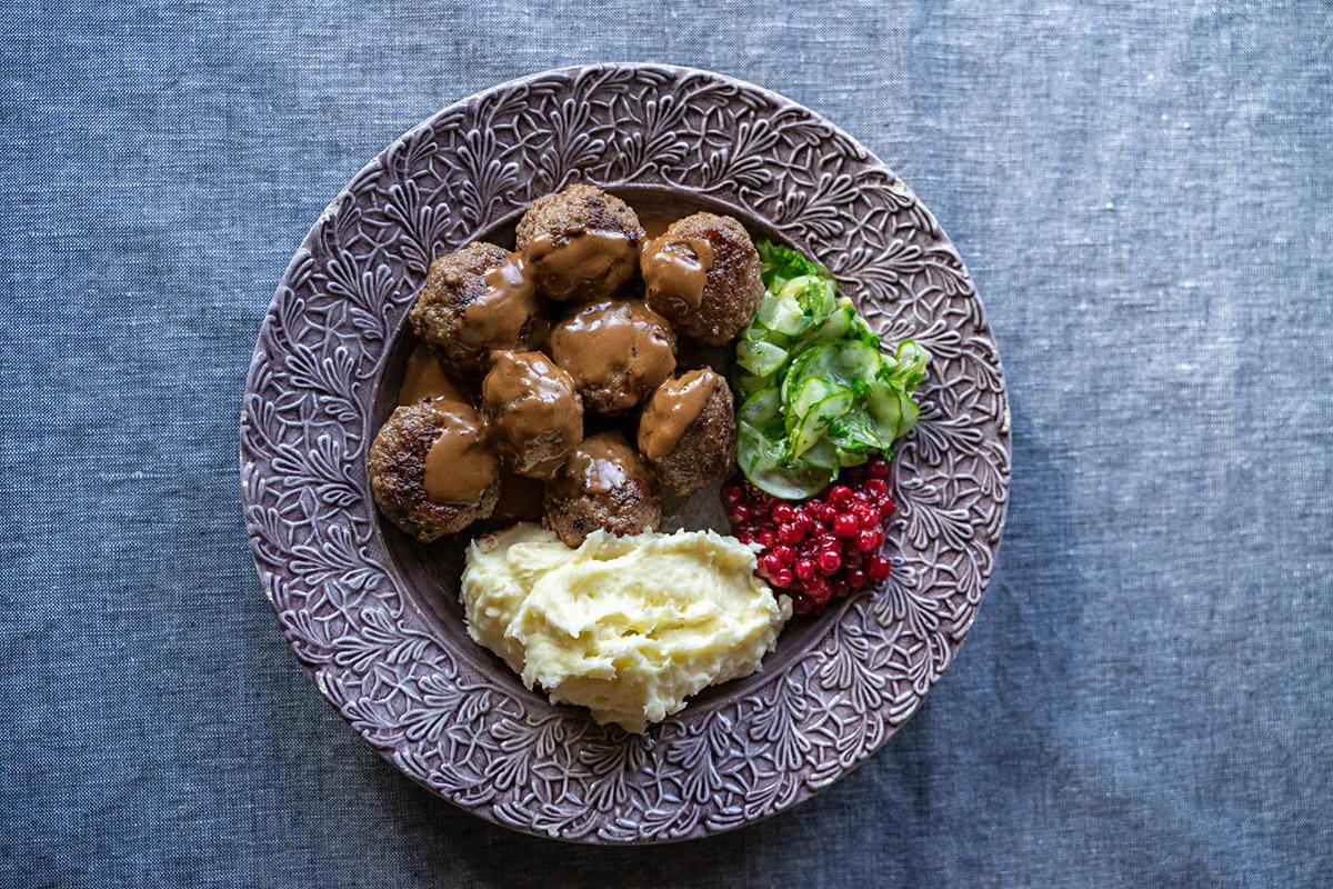 Meatballs with mashed potatoes, lingonberries and cucumber.