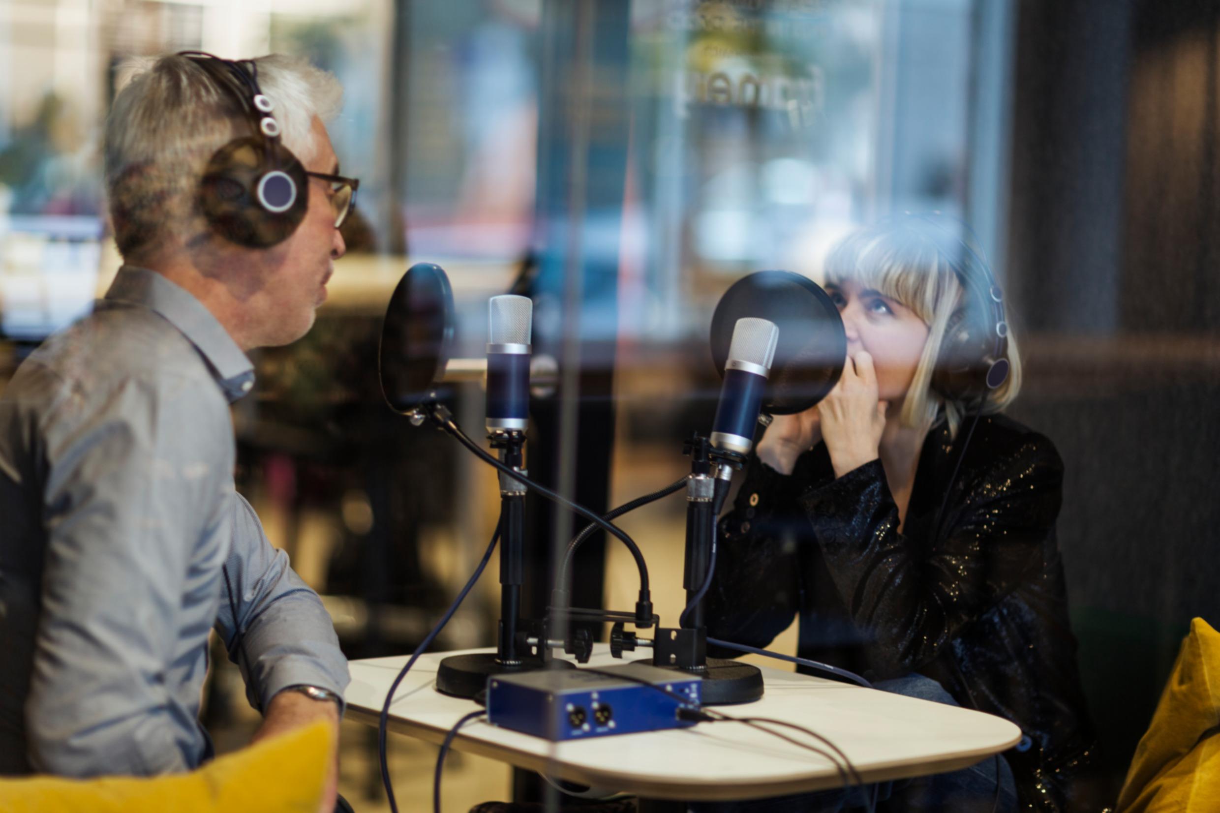 Two people with headsets in a radio studio.