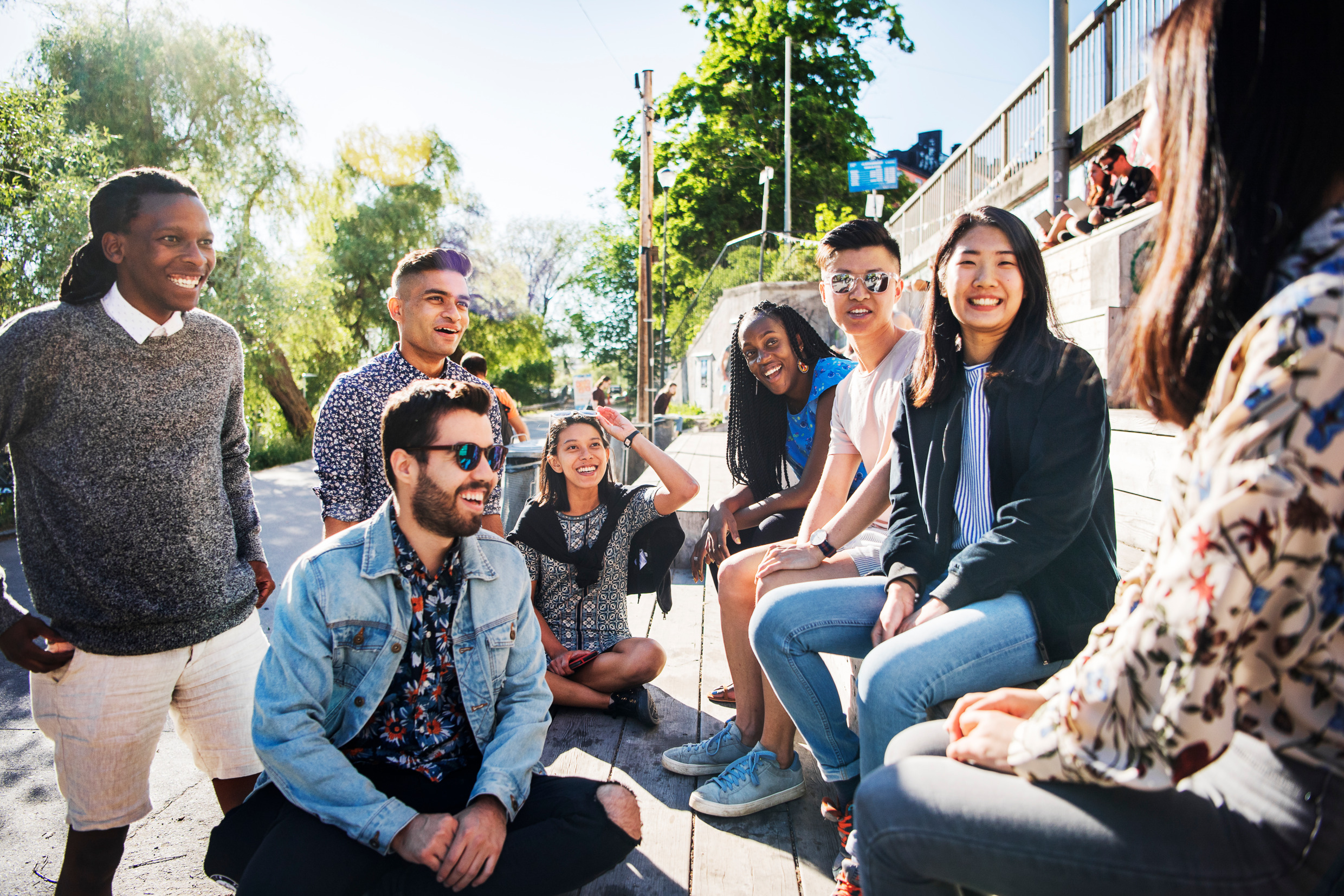 A group of students on a wooden terrace in the sun.