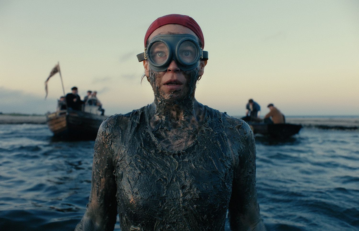 A woman swimming in the ocean, covered in tar.