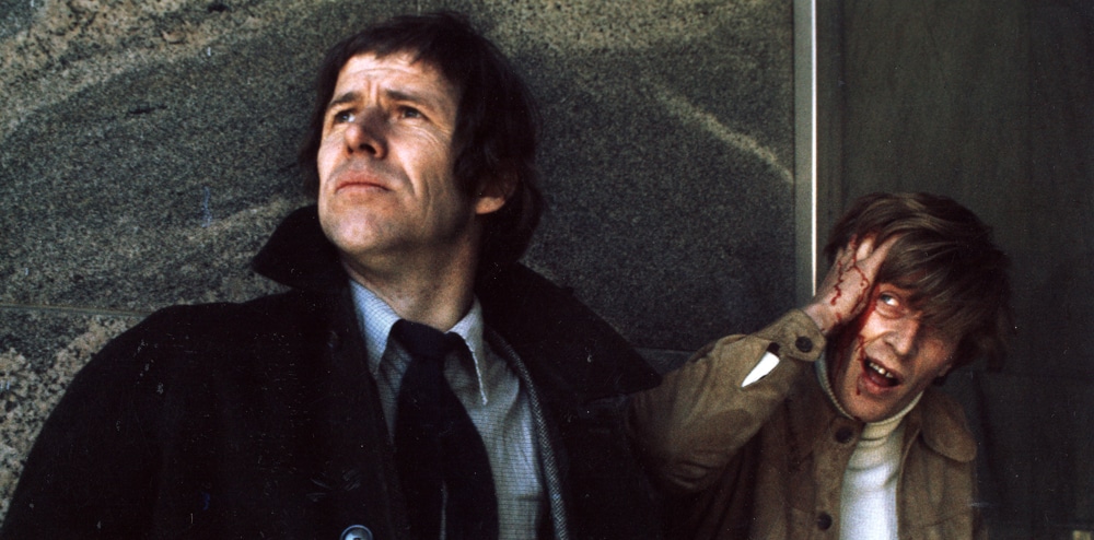 Two men hiding, one has been shot. 